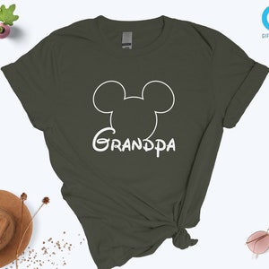May include: A dark green t-shirt with a white outline of Mickey Mouse's head and the word "Grandpa" underneath.