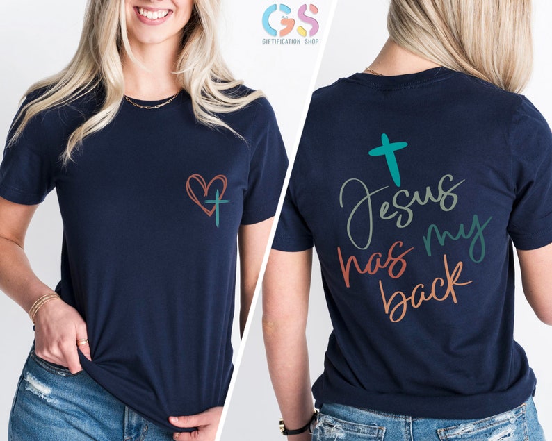 May include: Navy blue t-shirt with a heart and cross on the front and the text "Jesus has my back" on the back. The text is in a colorful script font.