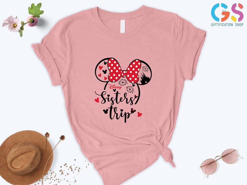 Puede incluir: Camiseta rosa con un dise&ntilde;o de orejas de Mickey Mouse en negro y rojo y el texto "Disney Sisters Trip".
