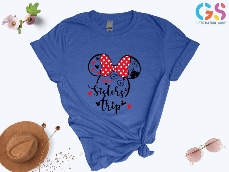 Puede incluir: Una camiseta azul real con un gr&aacute;fico en blanco y negro de orejas de Mickey Mouse con un lazo rojo y el texto "Sisters' Trip".