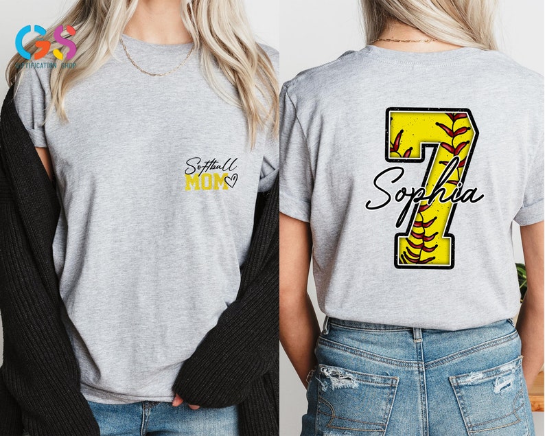 May include: Gray t-shirt with the text "Softball Mom" in yellow on the front and a yellow number 7 with red stitching and the name "Sophia" on the back.