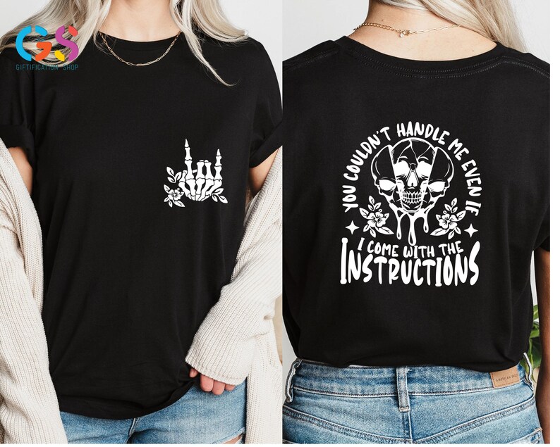 Op de afbeelding: Zwart T-shirt met een witte skelet hand die een rock and roll-teken maakt op de voorkant en de tekst "You couldn't handle me even if I come with the instructions" op de achterkant.
