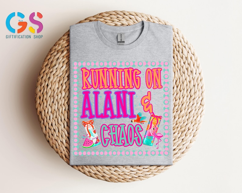Puede incluir: Una camiseta gris jaspeado con el texto "RUNNING ON ALANI & CHAOS" en rosa y naranja. El dise&ntilde;o incluye ilustraciones de un flamenco, un loro y una rodaja de sand&iacute;a. La camiseta est&aacute; doblada sobre una superficie circular tejida.