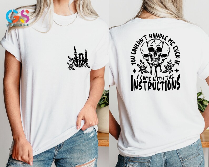 Op de afbeelding: Wit T-shirt met een zwart skelet handontwerp aan de voorkant en een schedelgrafiek met de tekst "You couldn't handle me even if I come with the instructions" aan de achterkant.