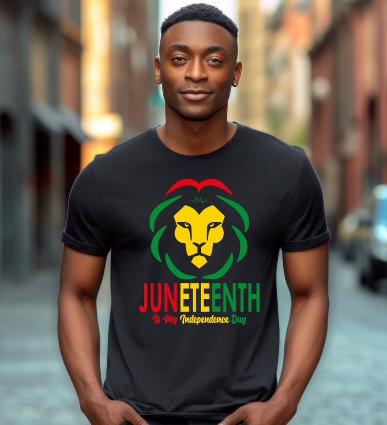 Pode incluir: Camiseta preta com um desenho de cabe&ccedil;a de le&atilde;o em amarelo, verde e vermelho, com o texto "Juneteenth Is My Independence Day". O design inclui o ano de 1865. A camiseta &eacute; de gola redonda.