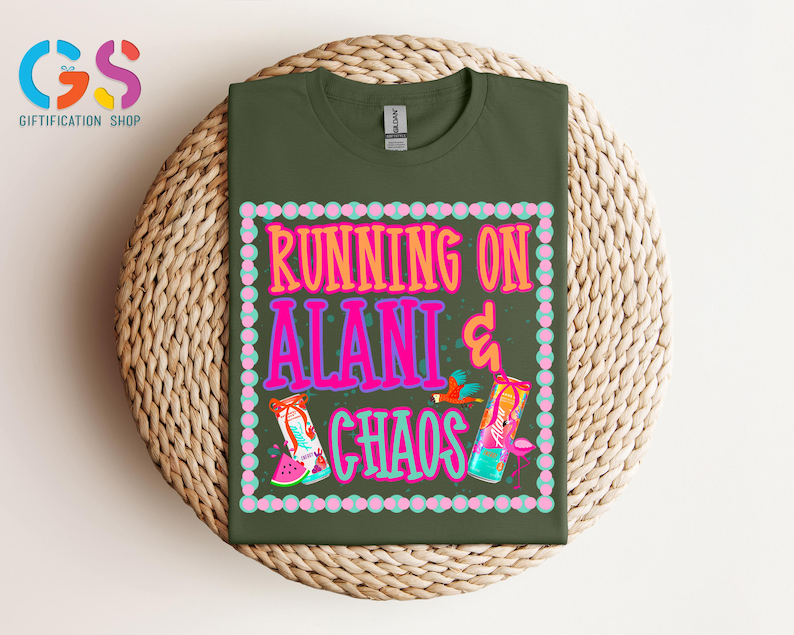 Puede incluir: Una camiseta verde oliva con el texto "RUNNING ON ALANI & CHAOS" en rosa y naranja, con ilustraciones coloridas. La camiseta se muestra sobre una superficie circular tejida.