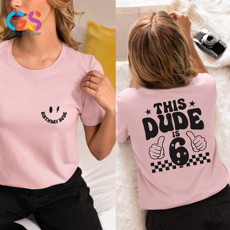 May include: Pink t-shirt with a smiling face and the text "Birthday Dude" on the front. The back of the shirt has the text "This Dude is 6" with a chequered pattern and two thumbs up.