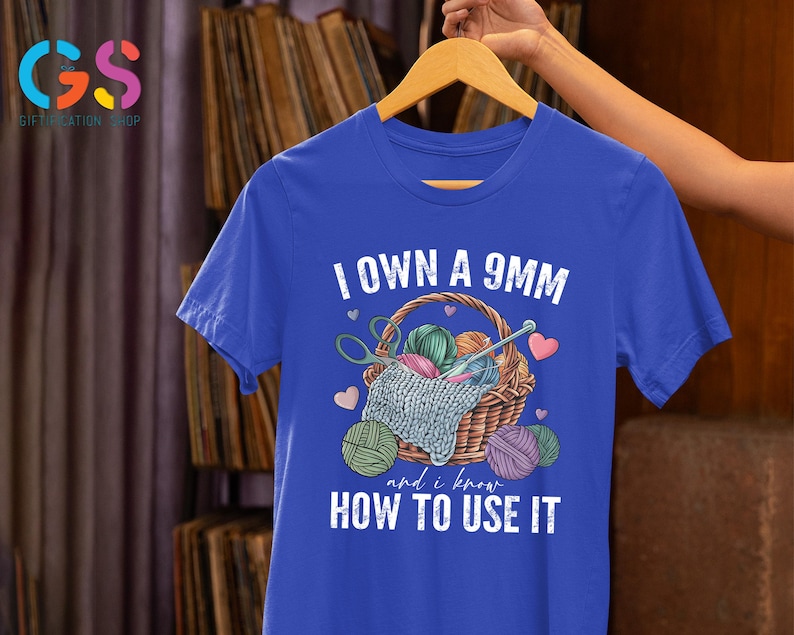 May include: A royal blue t-shirt with the text "I own a 9mm and I know how to use it". The text is white and the shirt features a graphic of a basket of yarn with knitting needles.