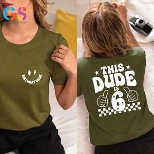 May include: Green t-shirt with a white smiley face graphic that says "Birthday Dude" on the front and "This Dude Is 6" with a thumbs up graphic on the back.