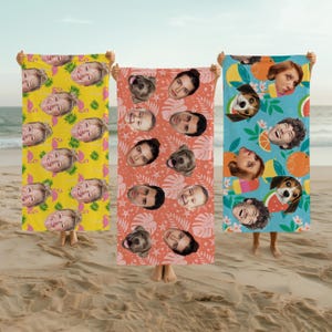 May include: Three rectangular beach towels featuring repeating patterns of human faces and dog faces. The yellow towel has pink flamingos and green leaves. The coral towel has white starfish and leaves. The blue towel has orange slices and flowers.