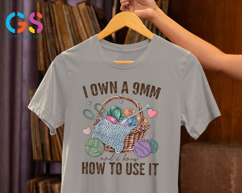 May include: Gray t-shirt with the text "I own a 9mm and I know how to use it". The shirt features a basket with yarn and knitting needles.