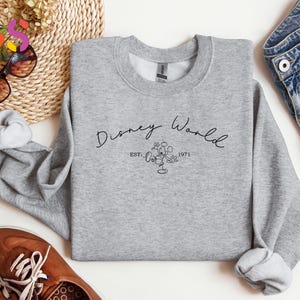 May include: Gray sweatshirt with the text "Disney World Est. 1971" and a black and white illustration of Mickey Mouse in a flower.