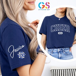 May include: Two navy blue t-shirts with white text. One shirt says "Cheer Mom" and the other says "Jessica" with a blue and white pom-pom graphic.