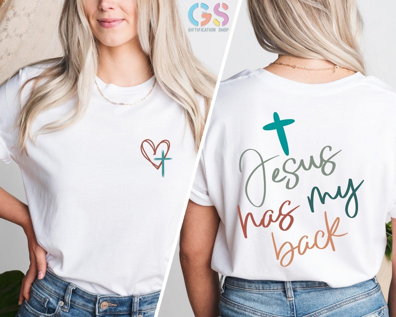 May include: White t-shirt with a red heart and a teal cross on the front and the text "Jesus has my back" in teal, green, and orange on the back.
