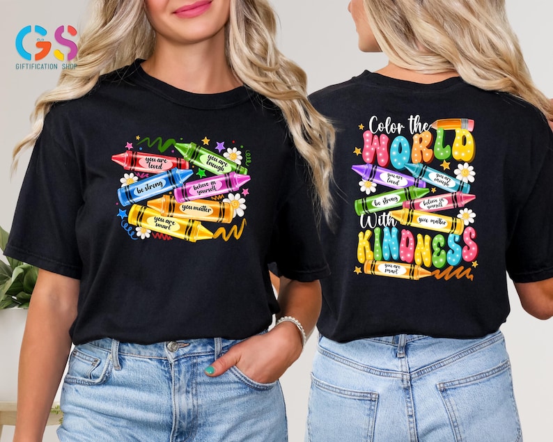 May include: Black t-shirt with a colorful crayon design and the text "Color the World with Kindness". The crayons have positive messages written on them, such as "You are loved", "Be strong", and "You matter".