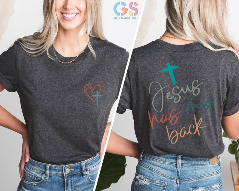 May include: A dark heather grey t-shirt with a small heart and cross design on the left chest and the text "Jesus has my back" with a cross on the back.