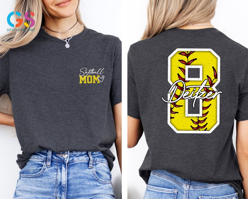 May include: A dark grey t-shirt with the text "Softball Mom" and a heart on the left chest. The back of the shirt has a yellow softball with red stitching and the number 8 with the name "Deitzel" written in white.