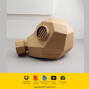 May include: A brown cardboard gas mask template featuring a geometric, faceted design with a circular filter housing and a slatted circular eye piece. The bottom yellow banner includes icons for cardboard templates, PDF, SVG, video, and real craft.