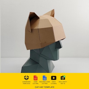 May include: A tan, geometric, low-poly paper cat hat template worn on a dark gray, faceted mannequin head. The bottom yellow banner displays icons for cardboard templates, PDF, SVG, hand cutting, machine cutting, video tutorial, and real craft.