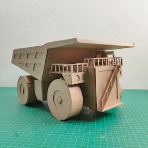 Plantilla de camión de minería de cartón. Patrón imprimible de bricolaje para crear un camión de transporte de cartón corrugado