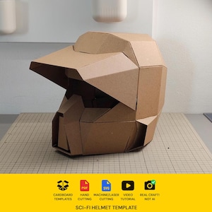 Op de afbeelding: Een bruine kartonnen helm met een geometrisch, hoekig ontwerp, voorzien van een prominente vizierrand en een gestructureerde voorplaat. De basis bevat iconen voor PDF, SVG, video-tutorial en echt handwerk, met de tekst SCI-FI HELMET TEMPLATE.