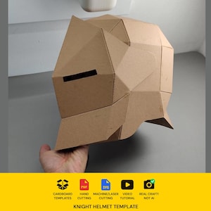 Puede incluir: Una plantilla de casco de caballero de cartón marrón claro con un diseño geométrico facetado y una ranura horizontal para los ojos. La parte inferior de la imagen incluye iconos de plantillas de cartón, PDF, SVG, tutorial en vídeo y el texto Knight Helmet Template.