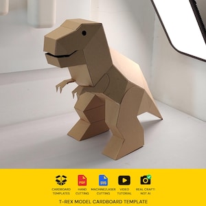 May include: A three-dimensional T-Rex model constructed from brown cardboard with geometric panels. Below the model, a yellow banner displays icons for cardboard templates, PDF, SVG, video tutorial, and real craft, with the text T-REX MODEL CARDBOARD TEMPLATE.