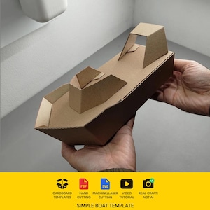 May include: A brown cardboard boat model featuring a pointed bow, a central cabin structure, and a rear canopy section. The base includes icons for cardboard templates, PDF, SVG, video tutorial, and real craft, with the text SIMPLE BOAT TEMPLATE.
