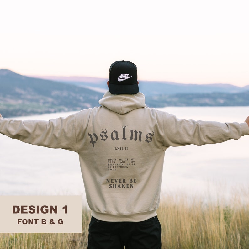 K&ouml;nnte beinhalten: Ein beiger Hoodie mit einem schwarzen Nike-Logo auf der Kapuze und den Worten "psalms" und "LXII:11" auf der R&uuml;ckseite. Der Text lautet "Truly he is my rock and my salvation; he is my fortress. I will never be shaken."