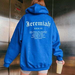 May include: A royal blue hoodie with a white print that reads "Jeremiah XXIX:XI" and a bible verse about peace and hope.