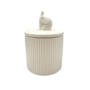 May include: A cream-colored ceramic jar with a lid and a small elephant figurine on top. The jar has vertical ribbed detailing. The elephant is in a sitting position with its trunk raised. The jar is likely used for storage or decoration.