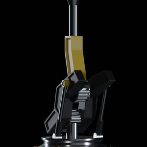 May include: A black and gold metal gear shifter with a black base and a tall, black lever. The lever has a gold top and is attached to a series of gears.