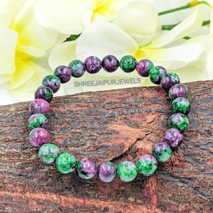 May include: A green and pink gemstone bracelet with round beads. The bracelet is made of natural stones and is a beautiful piece of jewellery.
