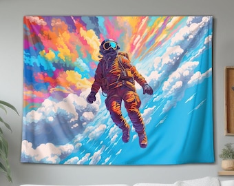 May include: A rectangular wall tapestry featuring a vibrant, colourful illustration of an astronaut floating amidst a sky filled with bright, multi-coloured clouds in shades of pink, orange, yellow, and blue, set against a clear sky background.