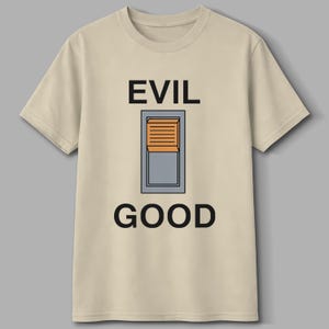May include: A beige t-shirt with the words "EVIL" and "GOOD" printed in black, with a graphic of a switch in between. The switch is gray with an orange shutter.