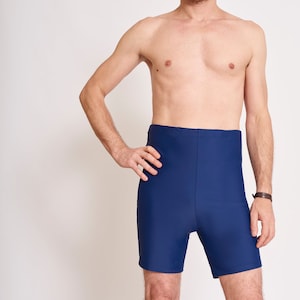 Può includere: Un costume da bagno blu scuro con vita alta e gambe corte.