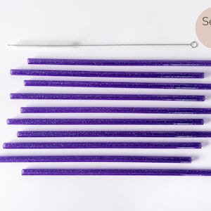 May include: Set of 10 purple glitter reusable drinking straws with a cleaning brush.