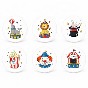 May include: Set of six white round decorative knobs with circus-themed illustrations. Designs include a seal balancing a ball, a lion, a magician's hat with rabbit ears, popcorn, a clown, and a ticket booth.