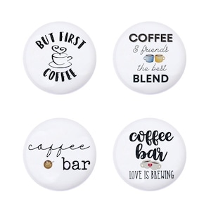 May include: Four white round buttons with black text and images. The first button says "But First Coffee" with a coffee cup and steam. The second button says "Coffee & friends the best BLEND" with two coffee cups. The third button says "coffee bar" with a coffee bean. The fourth button says "coffee bar LOVE IS BREWING" with two coffee cups with a heart.