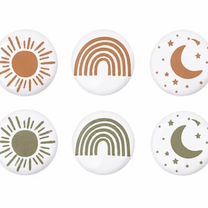 Puede incluir: Seis botones redondos blancos con diseños celestiales y meteorológicos. Los diseños incluyen un sol, un arcoíris y una luna con estrellas, en tonos marrones y verdes. Ideales para manualidades o ropa.