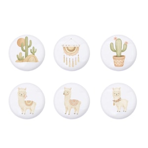 Könnte beinhalten: Sechs weiße Keramik-Schrankknöpfe mit Illustrationen zum Thema Wüste. Designs umfassen Kakteen, einen Traumfänger und Lamas in einer weichen, neutralen Farbpalette. Diese Knöpfe verleihen jedem Möbelstück einen Hauch von Bohème.