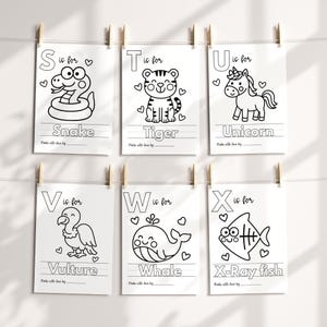 May include: Six white paper prints, each featuring a letter of the alphabet and a corresponding animal illustration in black outline. The letters are S, T, U, V, W, and X. Each print includes the animal's name and a space for writing.