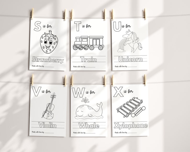 May include: Black and white printable alphabet flashcards featuring a letter, an illustration, and the word for the illustration. The letters are S, T, U, V, W, and X. The illustrations are a strawberry, a train, a unicorn, a violin, a whale, and a xylophone.