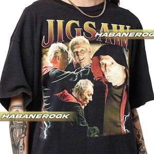 Könnte beinhalten: Schwarzes T-Shirt mit einem Grafikdruck von vier Personen aus dem Film "Saw". Der Text "Jigsaw" ist über dem Bild gedruckt. Der Text "HABANERO" ist auf der rechten Seite des Bildes gedruckt.