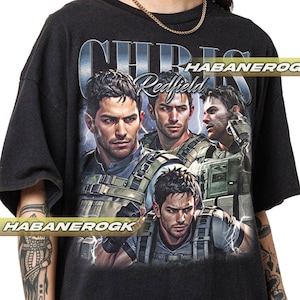 May include: Black t-shirt with a graphic print of Chris Redfield from the Resident Evil video game series. The graphic features four different images of Chris Redfield in various poses, with the text "Chris Redfield" printed in a stylized font.