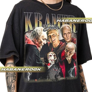 Könnte beinhalten: Schwarzes T-Shirt mit einem Vintage-Grafikdruck von vier Männern und einer Puppe. Die Grafik enthält den Text "Kramer John" und Blitze.
