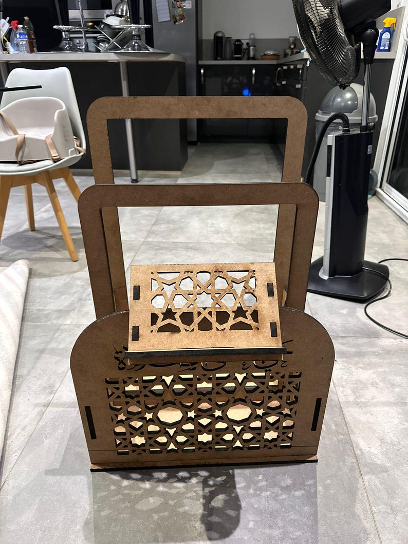 May include: A wooden decorative shelf with intricate geometric patterns cut into the wood. The shelf has two levels and is made of light brown wood.