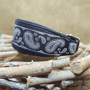Könnte beinhalten: Schwarzes Hundehalsband mit silbernem Paisley-Muster. Das Halsband hat eine Metallschnalle und besteht aus strapazierfähigem Material. Das Paisley-Design ist aufwendig gestickt. Dieses Halsband ist auf Komfort und Stil ausgelegt.
