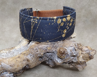 May include: A black and gold patterned dog collar with a brown webbing lining.