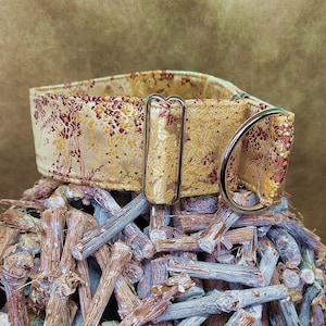 May include: A gold and red patterned dog collar with a silver buckle and D-ring.